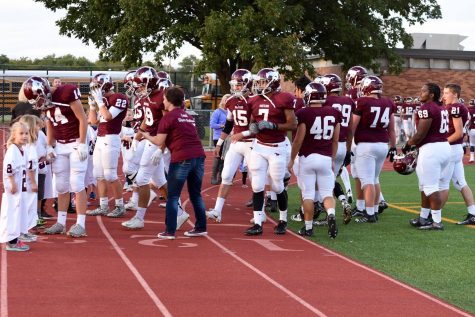 The football team coming out to meet their littles.