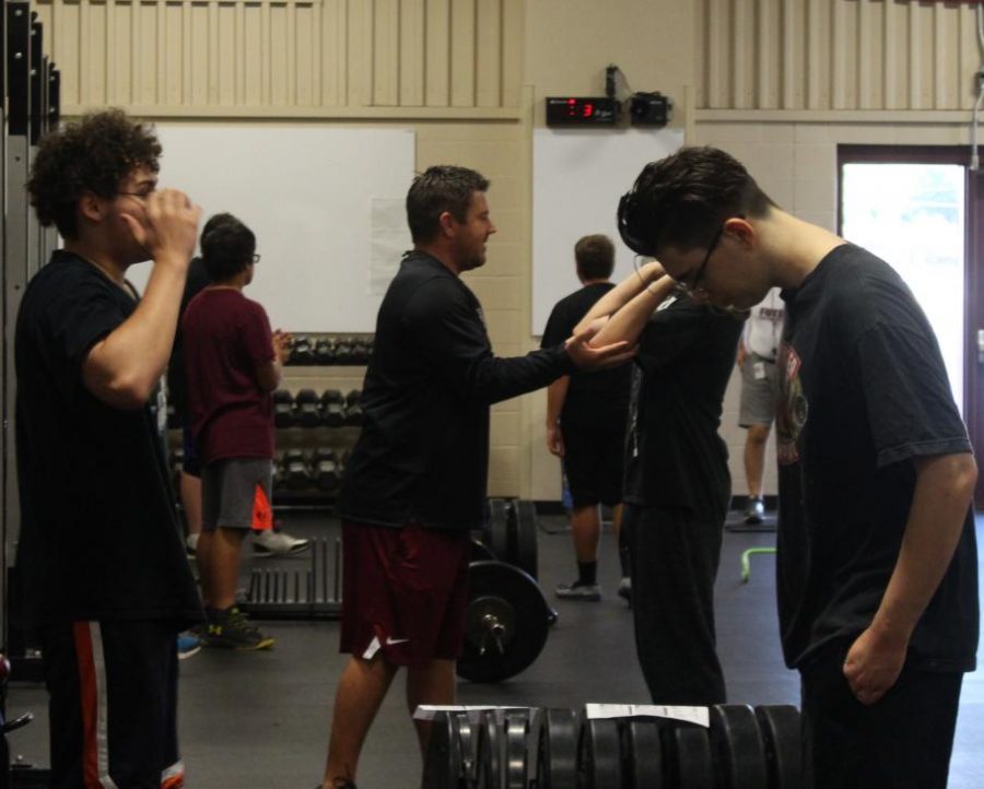 Coach+Sandbo+teaching+a+student+how+to+lift+the+weights+properly%2C+without+injuring+himself+or+others.