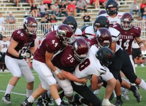 Mustang defenders Charles Slothower (44), Zach Calisti (75), Dawson Hogan (14) and Hunter Swolensky (66) gang tackle a ball carrier during Centrals victory over Emporia last Friday. 
